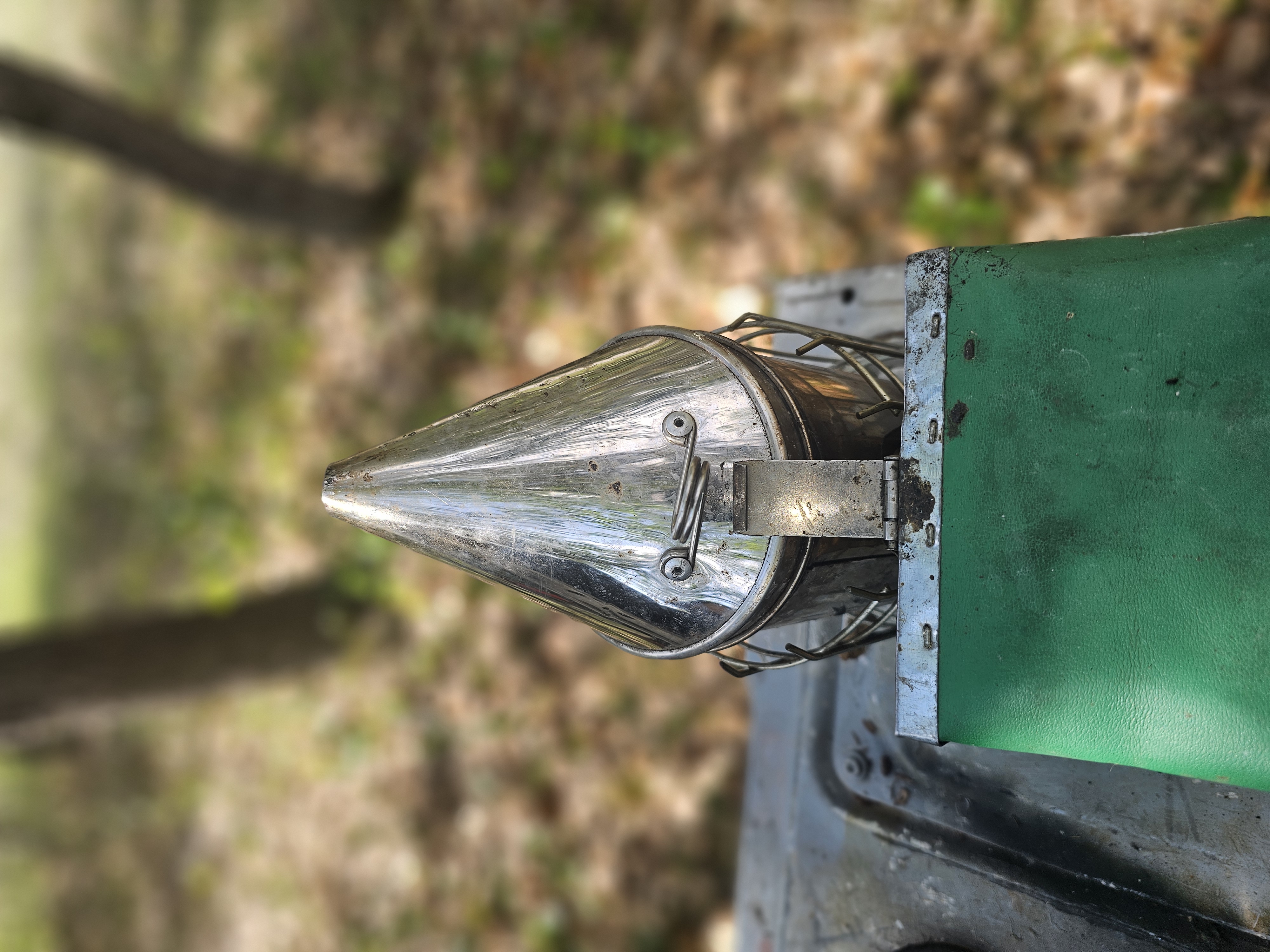 A close-up of youth carefully harvesting honey from a beehive frame.